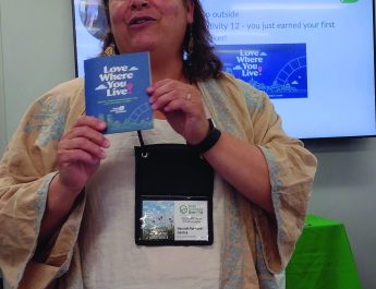 Hannah Rennard-Ganley, with Keep Omaha Beautiful, talks about a booklet on eco-friendly living during the Keep Nebraska Beautiful conference in Lincoln during the first week in June.